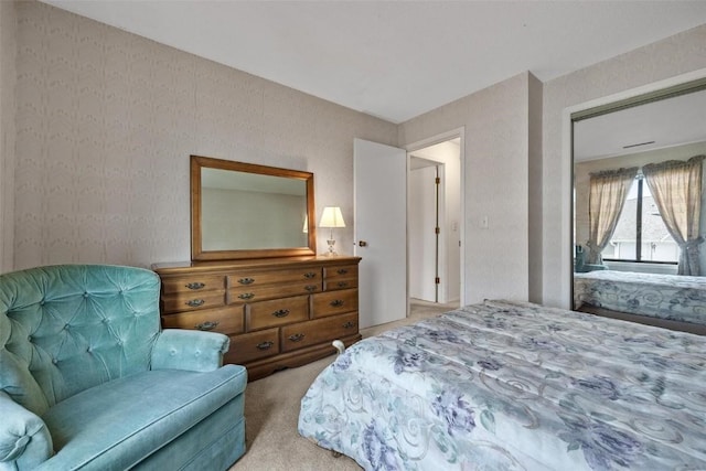 bedroom with light carpet and wallpapered walls