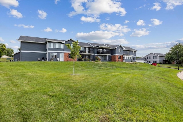 rear view of property with a residential view, brick siding, and a lawn