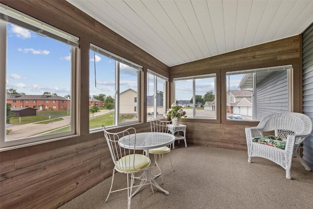 sunroom / solarium with wood ceiling, plenty of natural light, and a residential view