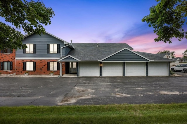 view of front facade with driveway and brick siding