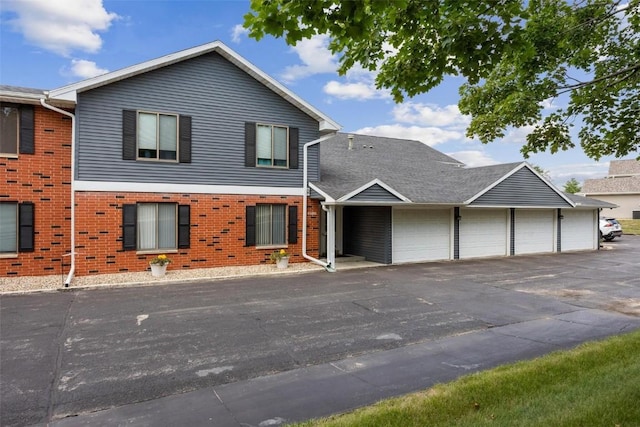 view of front facade with brick siding and community garages