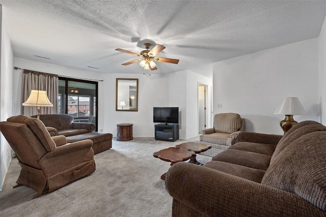 living room featuring light carpet, ceiling fan, and a textured ceiling