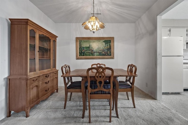 dining area featuring a chandelier and light colored carpet