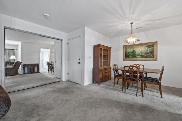 dining space with a textured ceiling and carpet flooring