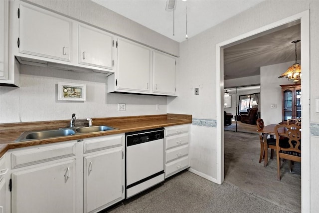 kitchen with white dishwasher, butcher block countertops, a sink, white cabinets, and decorative light fixtures