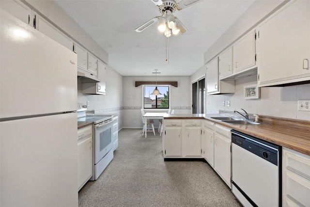 kitchen with white appliances, white cabinets, ceiling fan, a peninsula, and a sink