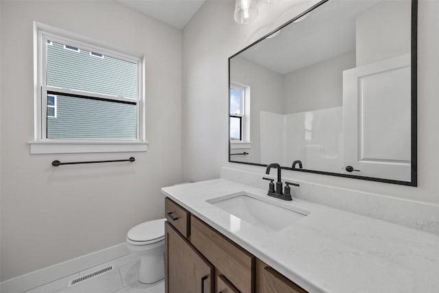 bathroom featuring a shower, toilet, and vanity