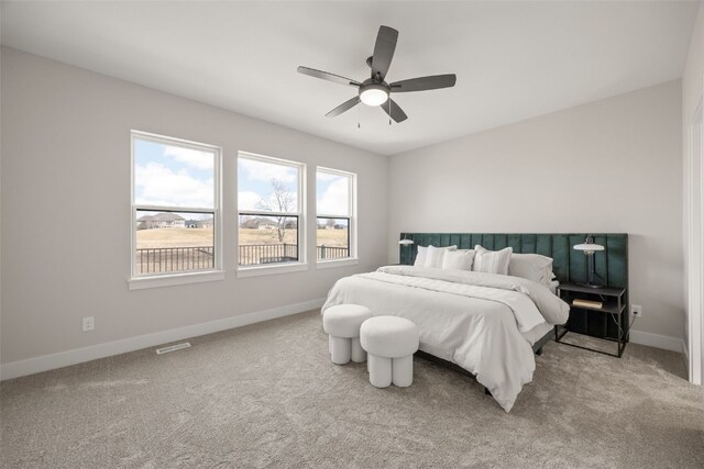 carpeted bedroom with visible vents, ceiling fan, and baseboards