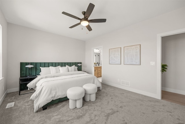 bedroom featuring carpet floors, ceiling fan, ensuite bathroom, baseboards, and visible vents