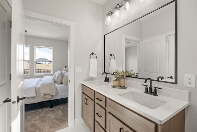 ensuite bathroom featuring double vanity, ensuite bath, and a sink