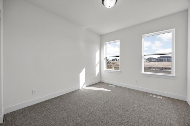 spare room featuring visible vents, carpet flooring, and baseboards