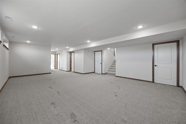 finished basement with recessed lighting, stairway, light carpet, and baseboards
