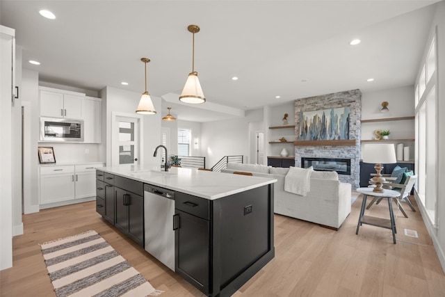 kitchen featuring white cabinetry, a center island with sink, appliances with stainless steel finishes, and a sink
