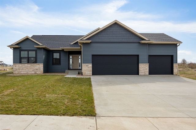 view of front of property featuring driveway, a garage, a front yard, and stone siding