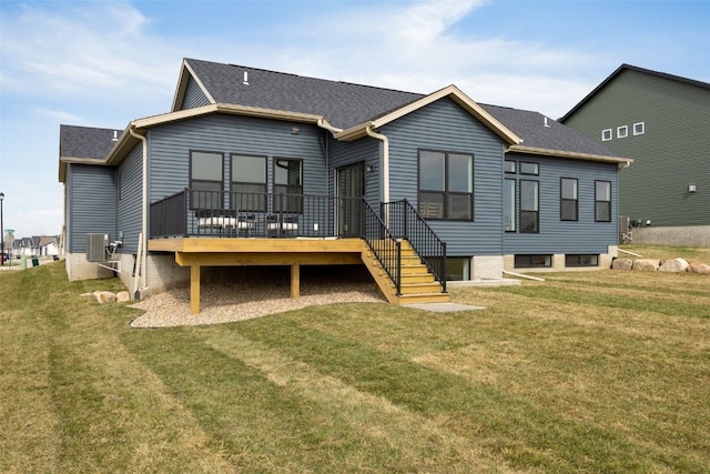 rear view of property featuring a lawn, a wooden deck, a shingled roof, and central air condition unit