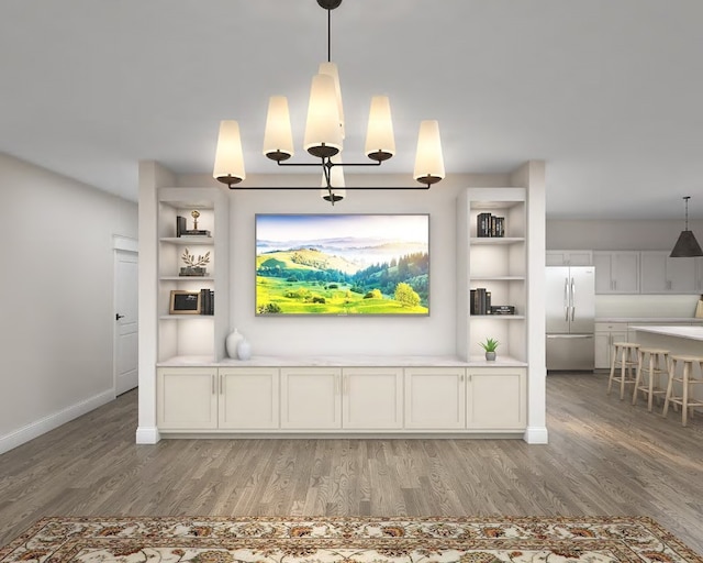 unfurnished living room with built in shelves and hardwood / wood-style flooring