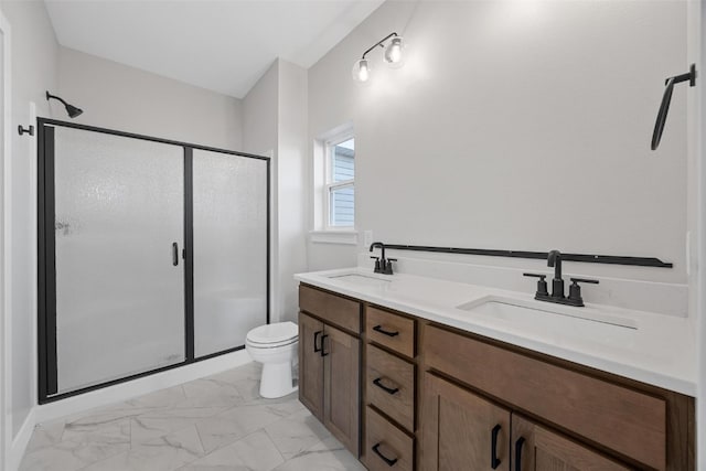 bathroom featuring vanity, toilet, and a shower with door