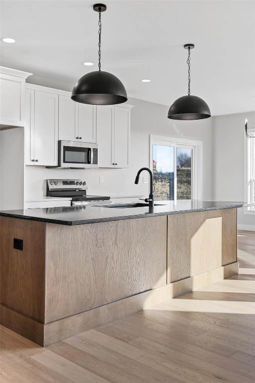 kitchen featuring pendant lighting, white cabinets, and stainless steel appliances