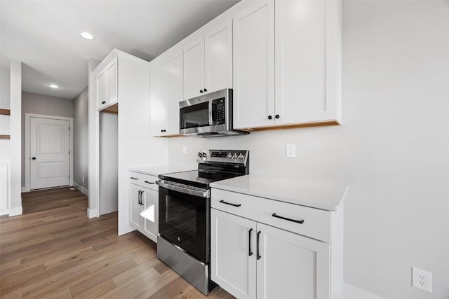 kitchen featuring light wood-type flooring, white cabinetry, and stainless steel appliances