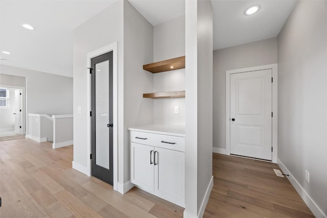 hallway with light hardwood / wood-style floors