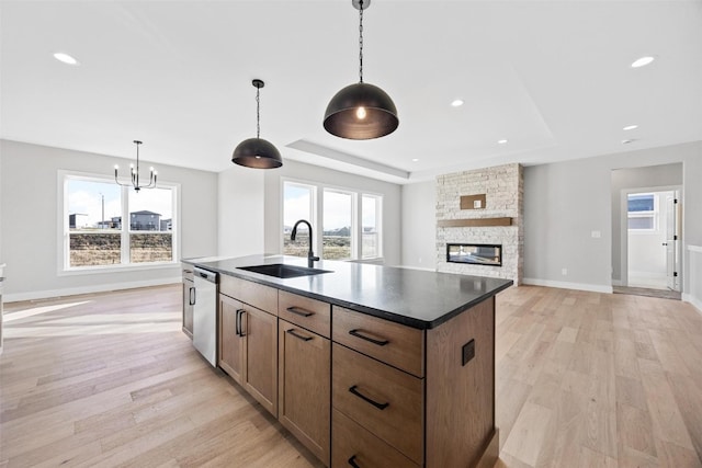 kitchen with light hardwood / wood-style floors, stainless steel dishwasher, a healthy amount of sunlight, and sink