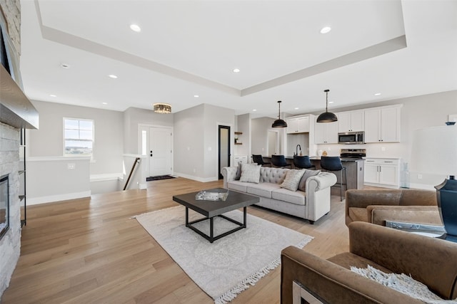 1510 Cardinal Dr, Fairfax, IA 52228 - living area with light wood-type flooring, a raised ceiling, baseboards, and recessed lighting