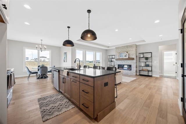 1510 Cardinal Dr, Fairfax, IA 52228 - kitchen with dark countertops, stainless steel dishwasher, a chandelier, a fireplace, and a sink