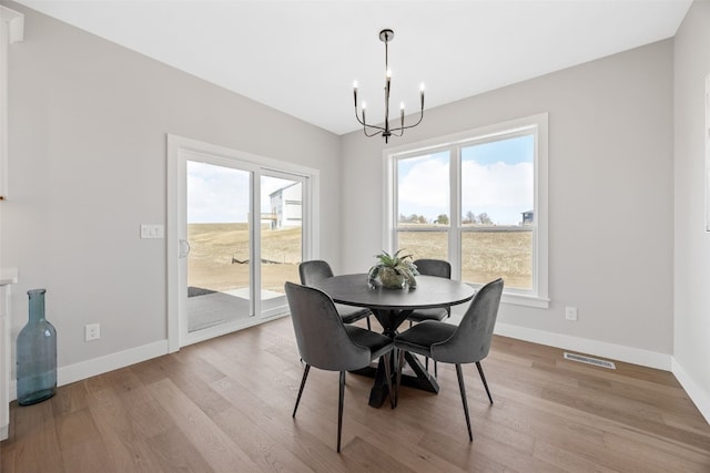 1510 Cardinal Dr, Fairfax, IA 52228 - dining area featuring a chandelier, baseboards, and light wood-type flooring