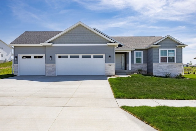 1510 Cardinal Dr, Fairfax, IA 52228 - craftsman house featuring stone siding, a garage, driveway, and a front lawn