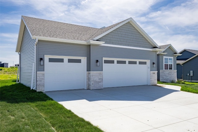 1510 Cardinal Dr, Fairfax, IA 52228 - view of front of house with a garage, stone siding, driveway, and a shingled roof