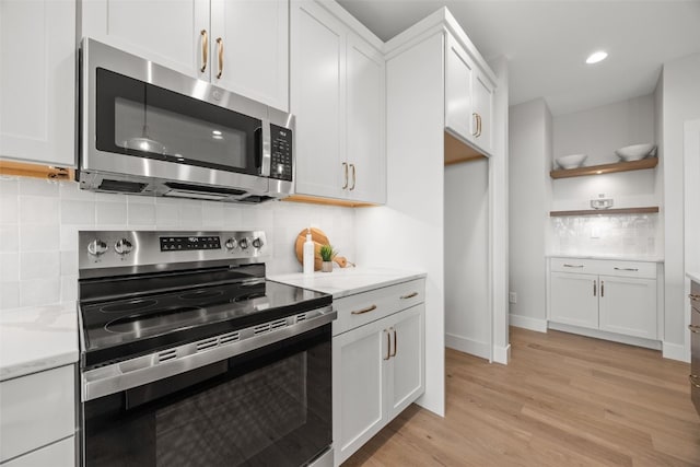 1519 Cardinal Dr, Fairfax, IA 52228 - kitchen with stainless steel appliances, open shelves, backsplash, light wood-style floors, and white cabinets