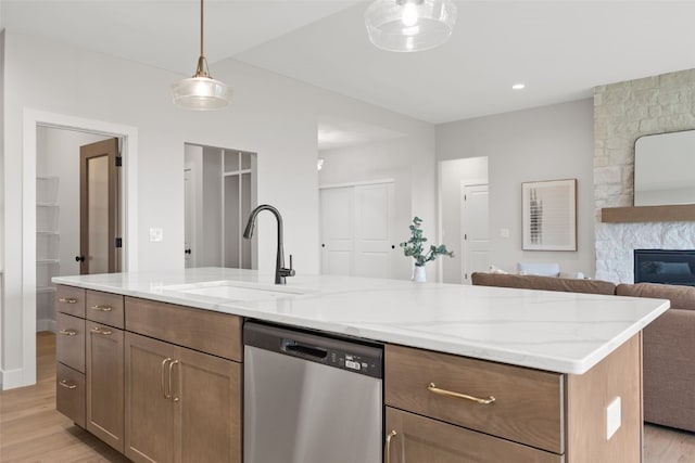 1519 Cardinal Dr, Fairfax, IA 52228 - kitchen with stainless steel dishwasher, light wood finished floors, open floor plan, a fireplace, and light stone countertops