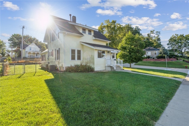 view of front of house with a front lawn and central AC unit