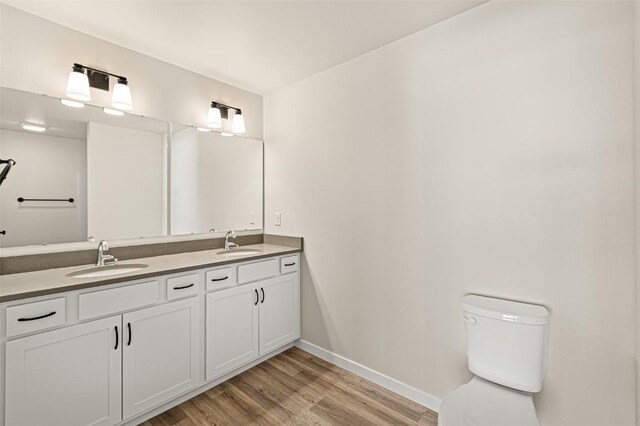 bathroom with vanity, toilet, and hardwood / wood-style flooring