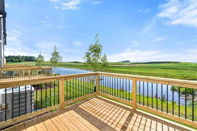 wooden deck with cooling unit, a rural view, and a water view