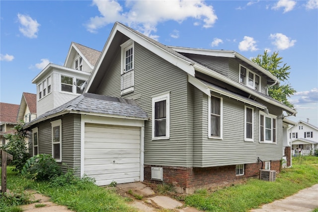 view of side of home with a garage and central AC unit