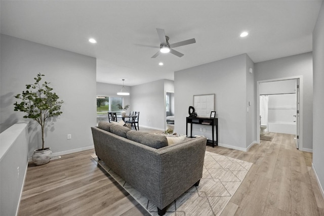 living room featuring light hardwood / wood-style floors and ceiling fan