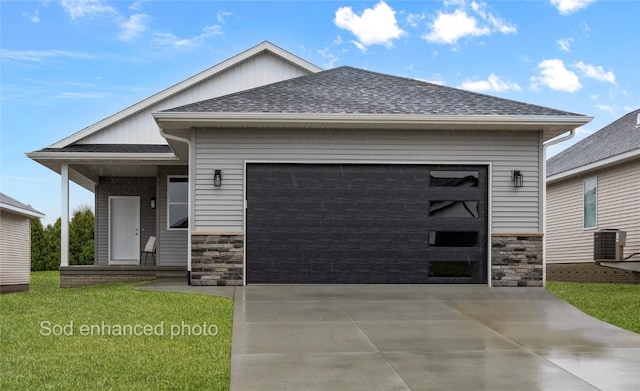 view of front of property featuring central air condition unit, a front yard, and a garage