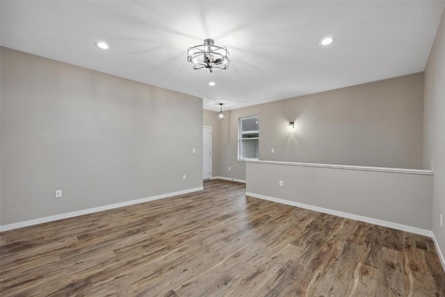 unfurnished room featuring wood-type flooring and a chandelier