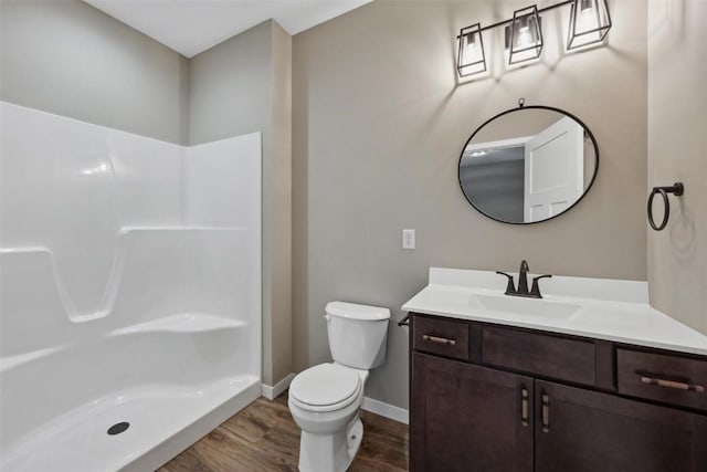 bathroom with hardwood / wood-style flooring, vanity, toilet, and walk in shower