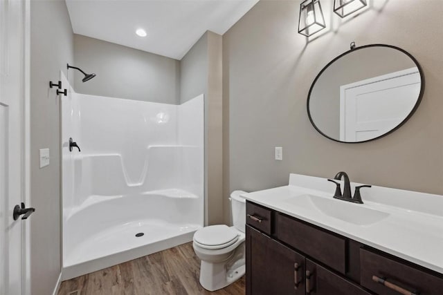 bathroom featuring a shower, hardwood / wood-style floors, vanity, and toilet