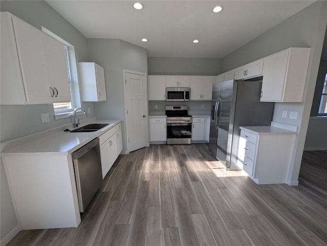 kitchen featuring white cabinets, hardwood / wood-style floors, stainless steel appliances, and sink