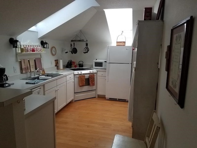 kitchen featuring white cabinetry, sink, light hardwood / wood-style flooring, white appliances, and vaulted ceiling with skylight