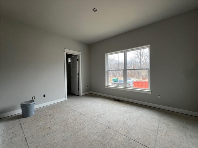 empty room featuring baseboards and visible vents