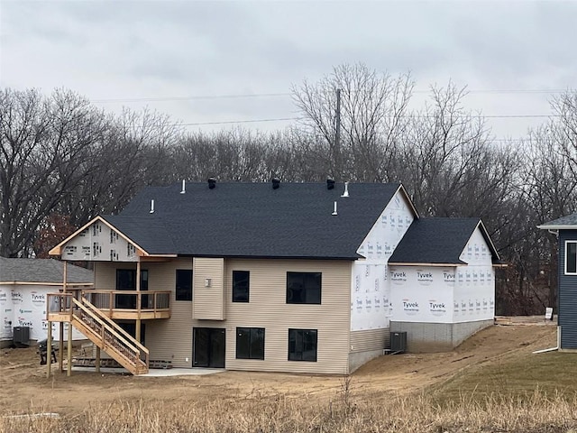 back of property featuring stairs, roof with shingles, a deck, and central air condition unit