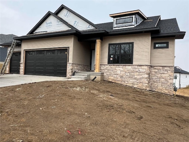 view of front facade featuring a garage, stone siding, driveway, and a shingled roof