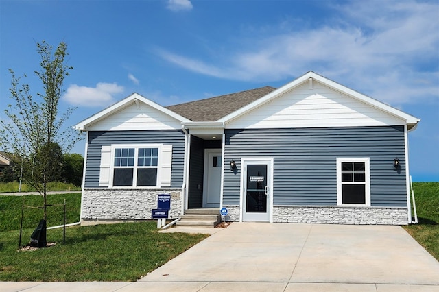 view of front facade with stone siding and a front lawn