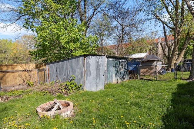 view of yard with a storage shed and an outdoor fire pit