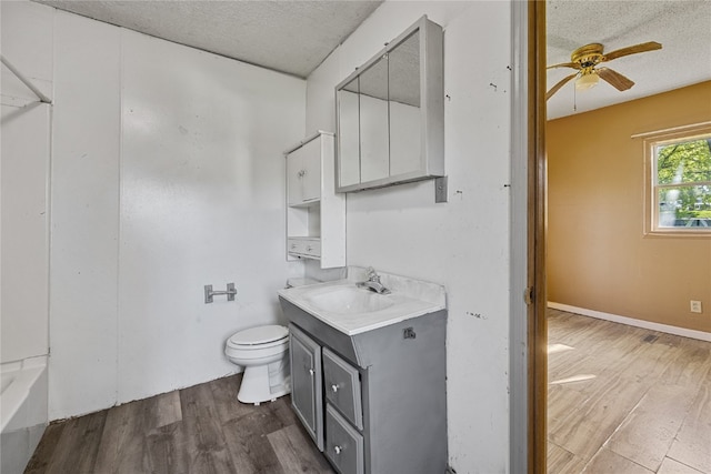 bathroom featuring wood-type flooring, vanity, toilet, and ceiling fan