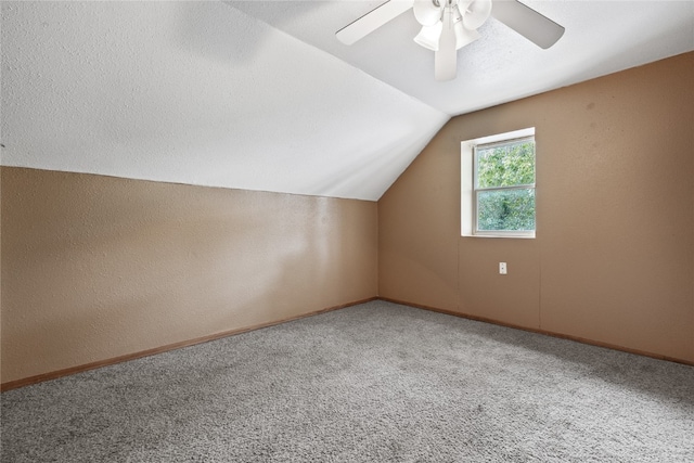 bonus room with a textured ceiling, lofted ceiling, carpet flooring, and ceiling fan